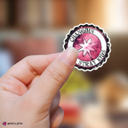 Hand holding a sticker with 'Changbin Stray Kids' logo against a blurred background