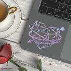Laptop with geometric heart design on a wooden surface with a cup of tea and rose.