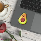 Laptop with an avocado sticker on a wooden surface with a cup of coffee and a rose.
