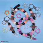 Colorful beaded keychain with bat charms on a blue background
