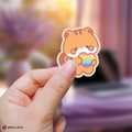 Hand holding a hongjoong aniteez sticker with a rainbow heart against a blurred background