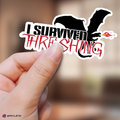 Fourth Wing sticker with 'I Survived Threshing' text held by a hand against a blurred background