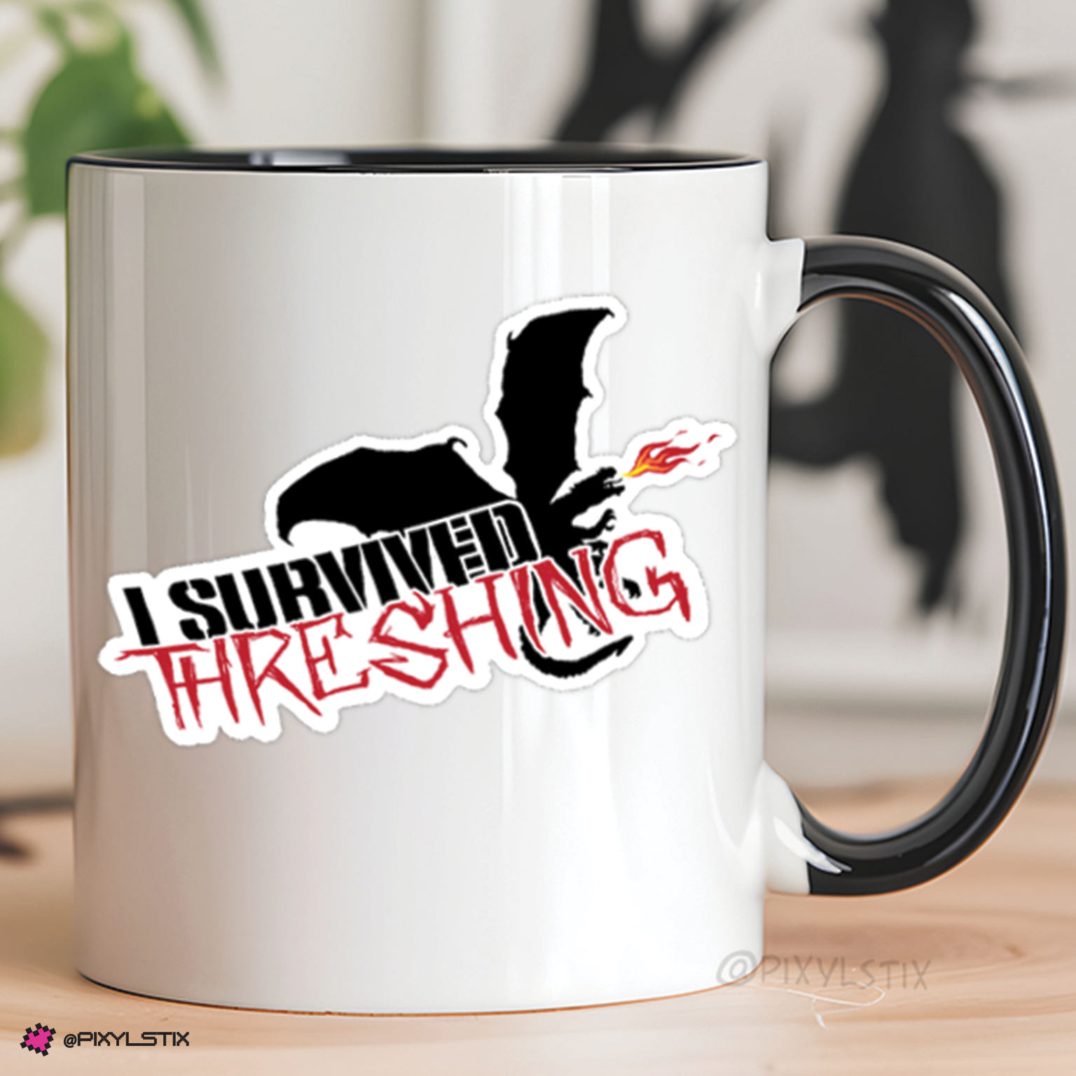 White mug with black handle featuring a graphic design and text on a blurred background