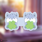 skzoo wolf chan bookmark holding a clover leaf with a blurred background