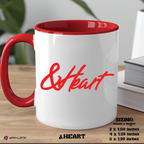 White mug with red interior and handle, featuring the brand '&HEART' on a wooden surface.