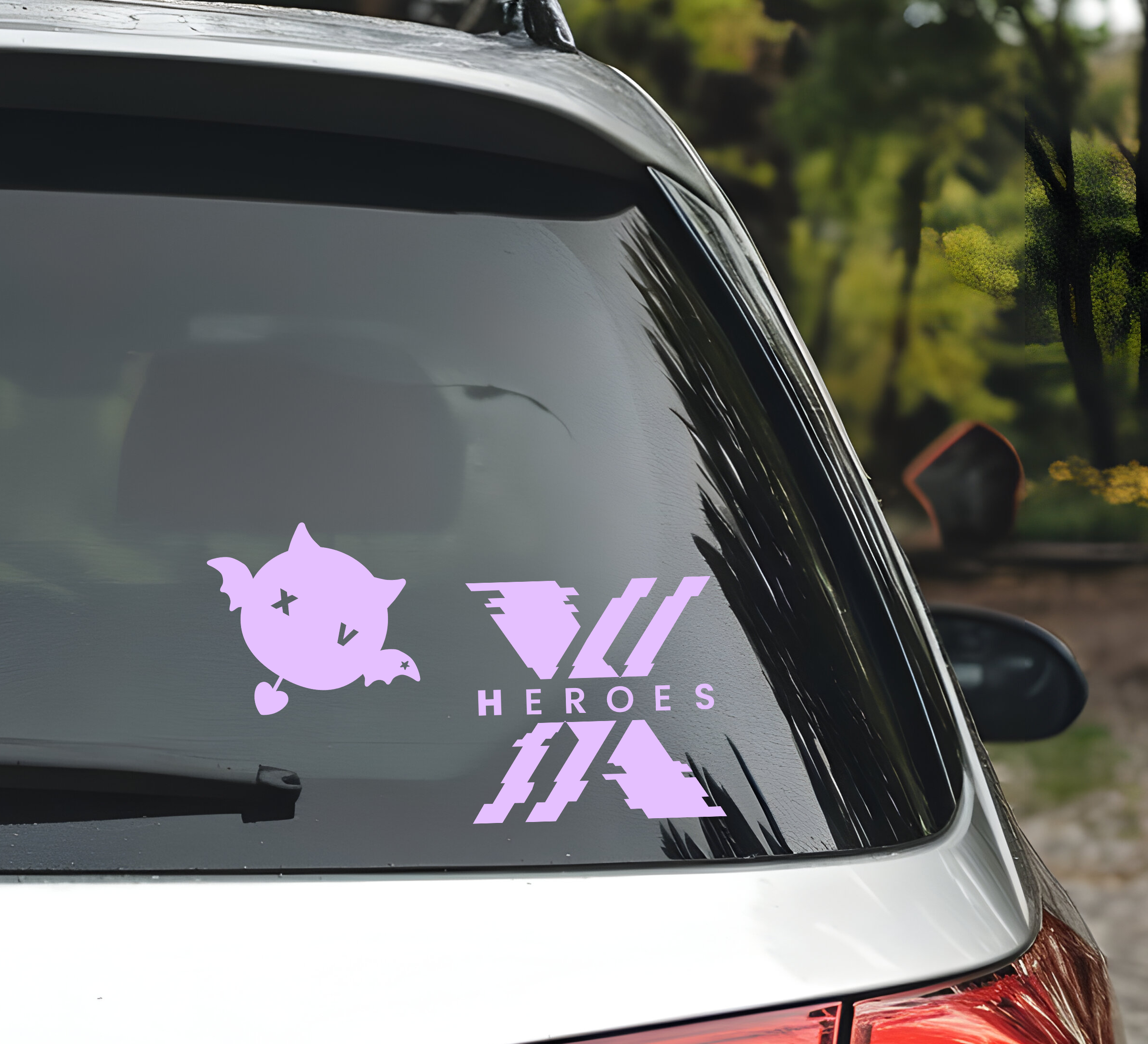 A light purple vinyl decal set applied to the rear window of a silver car. The decal features a bat on the left and a bold graphic on the right containing the text 'XDINARY HEROES' and three diagonal slash marks above it.