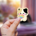 Hand holding a zeroni ricky sticker with rainbow colors against a blurred background